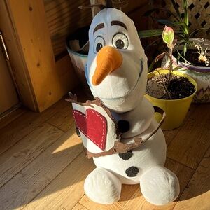 Olaf stuffed decoration, holding a valentine card with a heart.